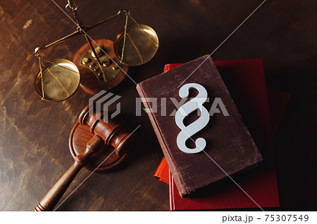 White paragraph symbol is on red law book and gavel in courtroom. Law and justice concept 75307549