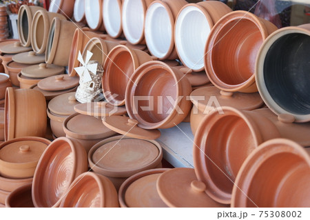 Many clay dishes on the shelf. 75308002