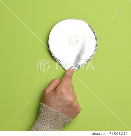 round aluminum thin lid for plastic yogurt jars on a green background round aluminum thin lid for plastic yogurt jars on a green background 75308212