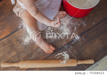 Little baby chef on wooden background. In apron. Close up. Macro photo.  75308423