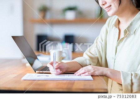 テレワークでメモする若い女性 テレワークでメモする若い女性 75312083