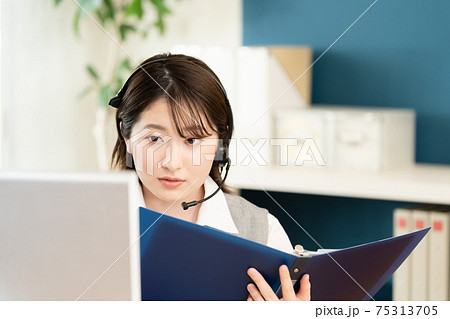 電話応対する若い女性 75313705