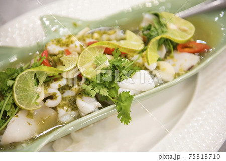 Steamed Squid with Lemon, hot and spicy squid steamed with lime - Thai food 75313710