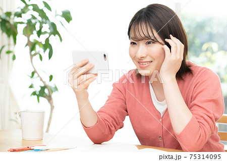 スマホでオンライン授業を受ける若い女性 スマホでオンライン授業を受ける若い女性 75314095