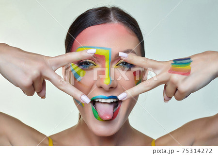 portrait of an attractive girl with bright makeup. A rainbow LGBT flag is depicted on her cheek portrait of an attractive girl with bright makeup. A rainbow LGBT flag is depicted on her cheek 75314272