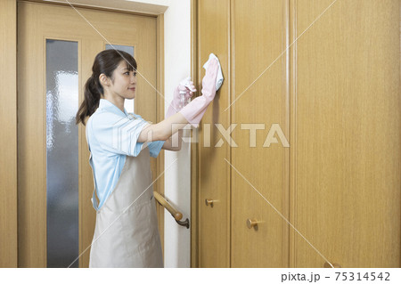 扉を拭くハウスクリーニングの女性作業員の後ろ姿 75314542
