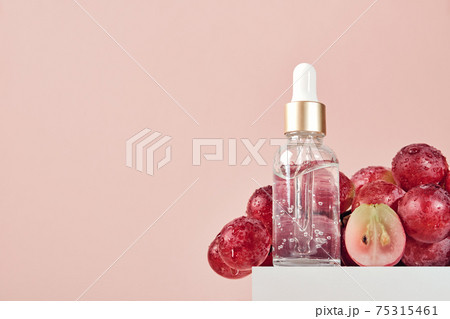 Organic cosmetics with grape seed oil. Zero Waste Winemaking. Skincare cosmetic product and grapes on podium Organic cosmetics with grape seed oil. Zero Waste Winemaking. Skincare cosmetic product and grapes on podium 75315461