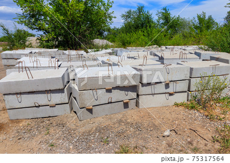 Stacks of the new concrete road curbs for road construction Stacks of the new concrete road curbs for road construction 75317564