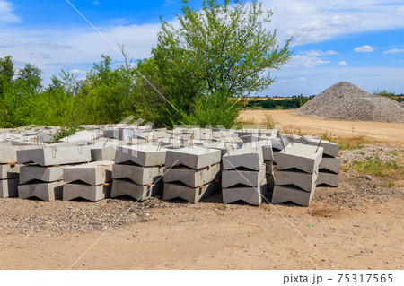 Stacks of the new concrete road curbs for road construction Stacks of the new concrete road curbs for road construction 75317565