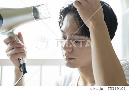 ドライヤーで髪の毛を乾かす男性 75319101
