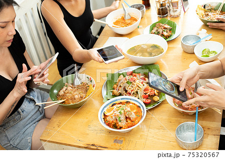 Girl takes photo with smart phone of Delicious and good looking Food Girl takes photo with smart phone of Delicious and good looking Food 75320567