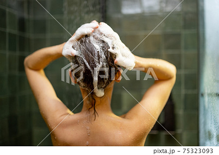 Woman taking shower relaxing under warm water Woman taking shower relaxing under warm water 75323093