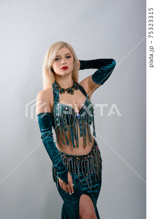 Young beautiful exotic eastern women performs belly dance in ethnic green dress. Young beautiful exotic eastern women performs belly dance in ethnic green dress. 75323315