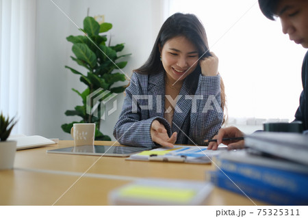 Two business people working with business documents and discussing new project in office. 75325311
