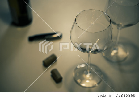 白ワイン シャルドネ のグラス2脚とワインのコルク栓とビンとワインオープナーの写真素材