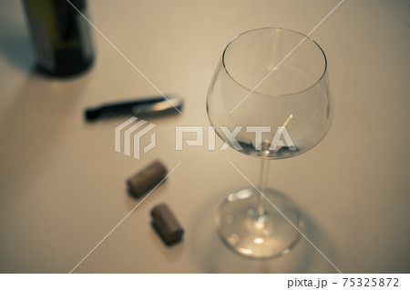 白ワイン(シャルドネ)のグラスとワインのコルク栓とビンとワインオープナー 75325872