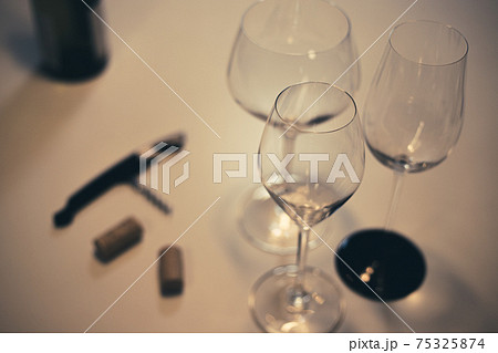 白ワインのグラスとワインのコルク栓とビンとワインオープナー 75325874