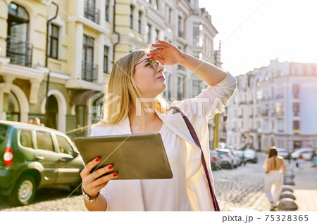 Young business woman in city using digital tablet Young business woman in city using digital tablet 75328365