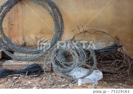 Rolls of used barbed wire used for building cattle fences 75329163