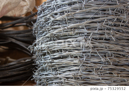 Rolls of barbed wire used for building cattle fences Rolls of barbed wire used for building cattle fences 75329552