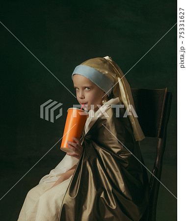 Medieval little girl as a lady with a pearl earring on dark studio background. Concept of comparison of eras, childhood. Stylish creative design, art vision, new look of artwork. 75331627