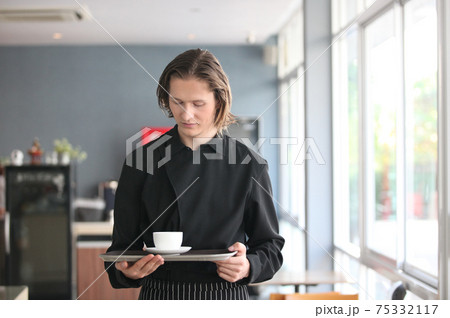 Handsome male barista is working in coffee shop Handsome male barista is working in coffee shop 75332117