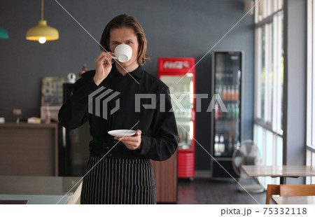 Handsome male barista is working in coffee shop Handsome male barista is working in coffee shop 75332118