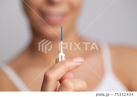 The woman uses brushes to clean the interdental spaces 75332434