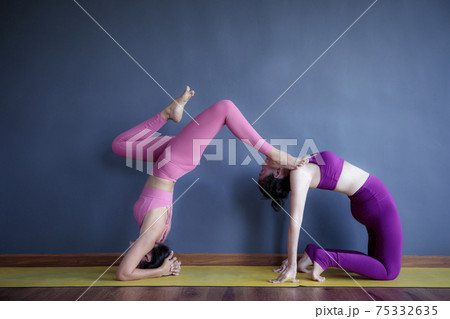 two woman doing yoga pose in home living room two woman doing yoga pose in home living room 75332635