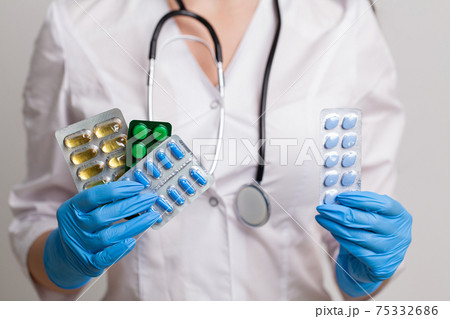 Closeup of female doctor holding pill for men health Closeup of female doctor holding pill for men health 75332686
