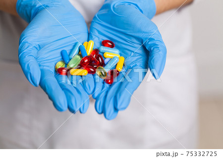 Doctor close up holding white pills for weight loss 75332725