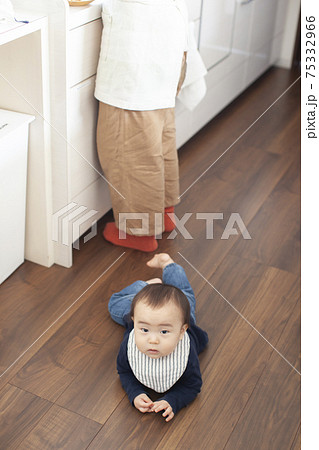 キッチンへ後追いする赤ちゃんの写真素材