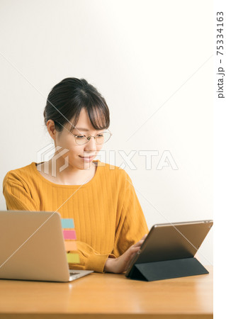 タブレットを操作する若い女性 75334163