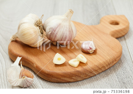 Ripe garlic heads on a wooden cutting board 75336198
