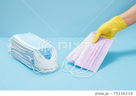 Female doctor in a glove holding medical masks in his hand. 75336319