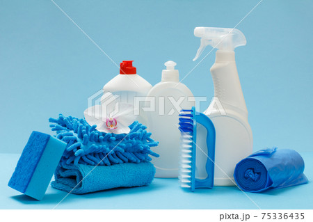 Bottles of detergent, a brush and sponges on the blue background. Bottles of detergent, a brush and sponges on the blue background. 75336435