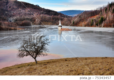 A flooded church in a toxic red lake. Water polluting by a copper mine A flooded church in a toxic red lake. Water polluting by a copper mine 75343457