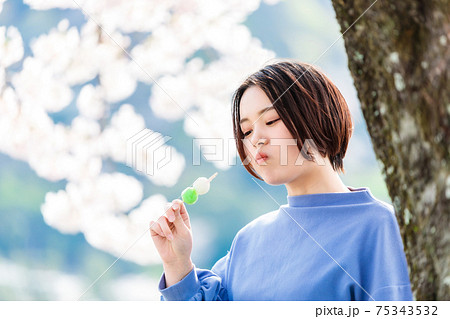 お花見でお団子を食べる女性 75343532