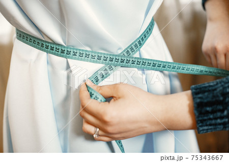 Woman skillfully sews clothes at home on sewing machines with all necessary tools Woman skillfully sews clothes at home on sewing machines with all necessary tools 75343667