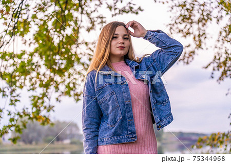 A young girl poses posing in a warm autumn evening. 75344968