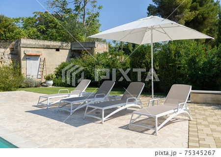 Sun beds on sunny day in the yard Sun beds on sunny day in the yard 75345267