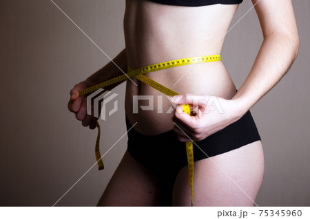 girl measures her volumes with a centimeter girl measures her volumes with a centimeter 75345960