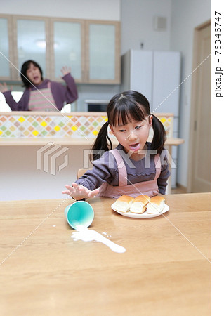 食事中に牛乳をこぼす娘 75346747