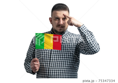 White guy holding a flag of Mali and a finger touches the temple on the head isolated on a white background 75347334