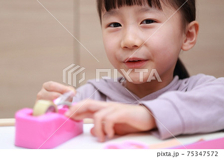 セロハンテープをカットして工作する女の子 75347572