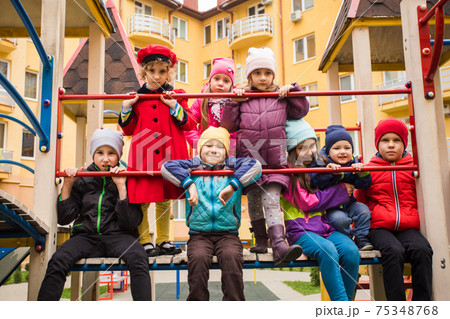 Cheerful kids at outdoor playground in early spring Cheerful kids at outdoor playground in early spring 75348768
