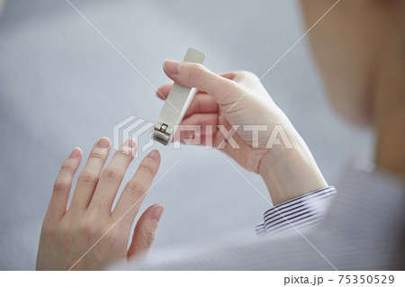 爪切りで爪を切る女性の手元 爪切りで爪を切る女性の手元 75350529