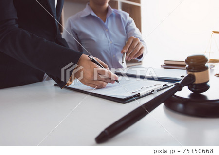 Legal advisor is explaining the offense under the law in the book at office. Legal advisor is explaining the offense under the law in the book at office. 75350668