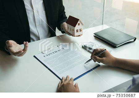 Hand of real estate agent passes the key to new homeowners in office with buyer house concept. 75350687