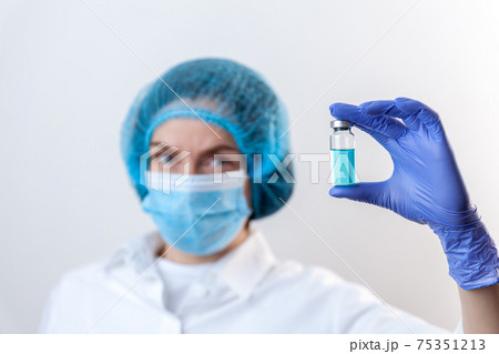 Doctor in gloves and mask holds bottle with vaccine, medicine 75351213